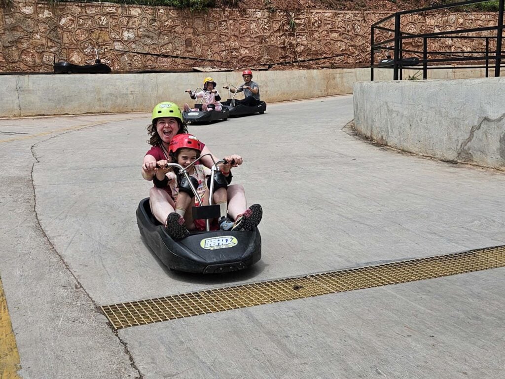 Alt: Familie met kinderen in helmen rijdt op motorboot op hellend wegdek.